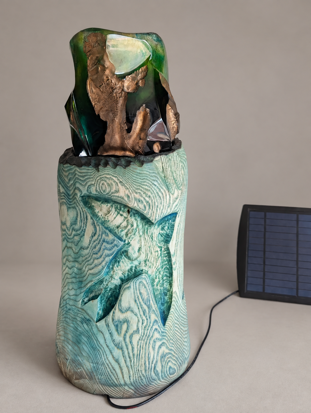 Back view of Emerald Swifts on a warm-grey studio background, with its solar panel and wire visible